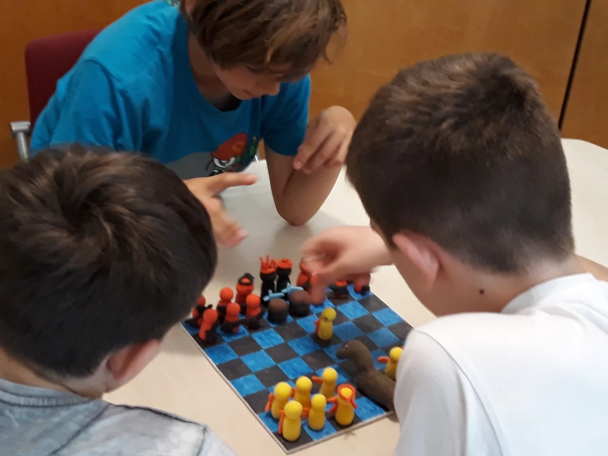 Taller de mitología Jugadores delante de un tablero de juego con sus piezas